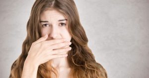 What are the Most Common Dental Problems - woman hiding her mouth with her hand
