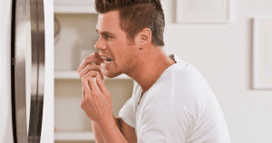 Do I Really Need to Floss? - man flossing his teeth in front of a mirror