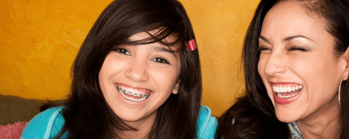 5 Reasons to Choose a Dentist for Braces - mother and daughter smiling together, daughter with braces