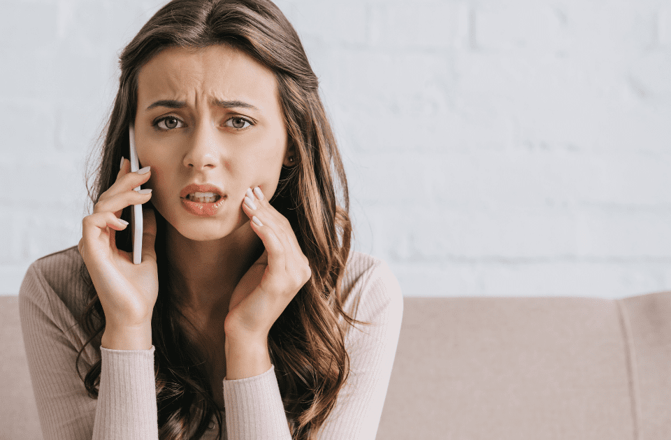 woman with tooth pain on phone - Emergency Dentist Clovis