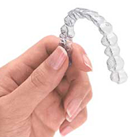how much does invisalign cost - hand holding invisalign device