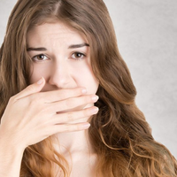 Do braces cause more plaque - woman hiding her mouth with her hand