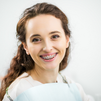 Do orthodontic braces hurt - smiling woman with braces