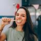 Woman brushing her teeth at the bathroom mirror