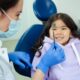 Dentist and a smiling young child during a friendly dental check-up