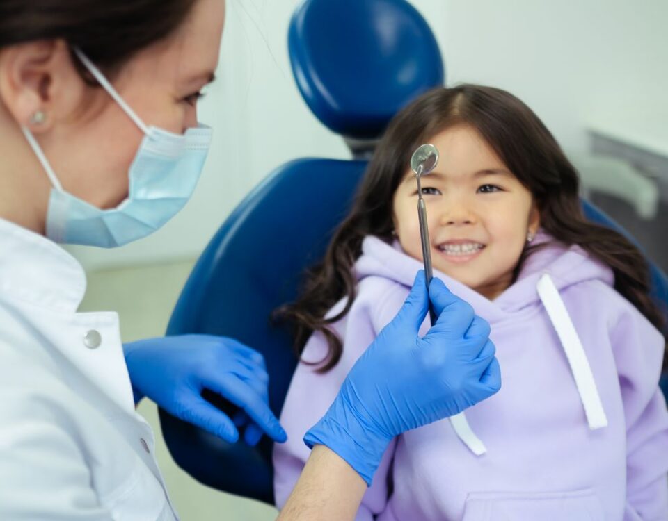 Dentist and a smiling young child during a friendly dental check-up