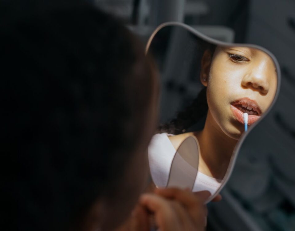 Child checking their teeth in a mirror at the dentist