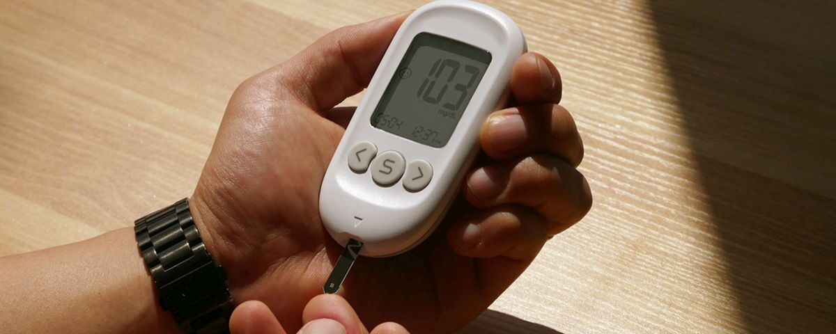 Person checking blood glucose with a meter