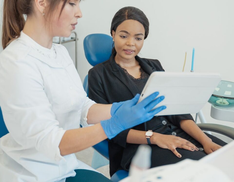 Dentist going through aftercare instructions with a patient on a tablet