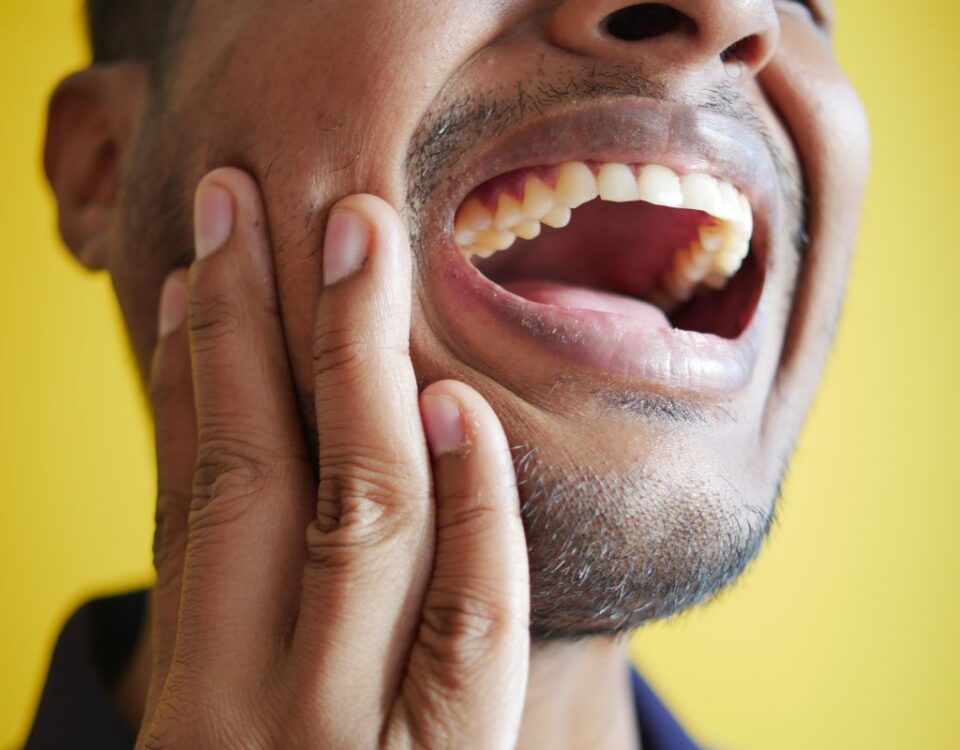 Man holding his jaw with dental pain needing emergency dental care