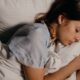 Woman asleep in bed, when night time teeth grinding happens