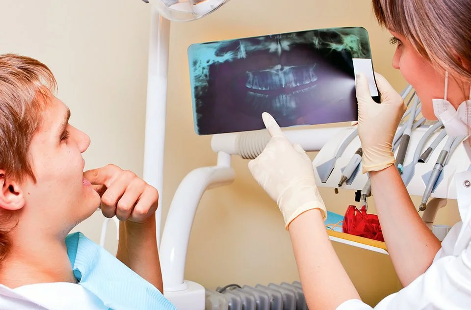 The Bare Bones Of Gum Recession, How to stop receding gums, young boy in dentist chair, exam by a female dental hygienist