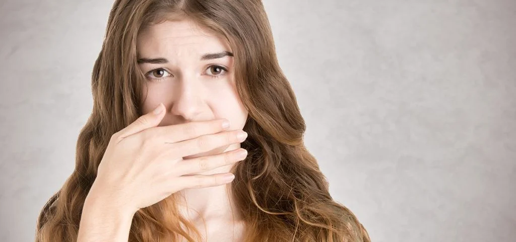 What are the Most Common Dental Problems - woman hiding her mouth with her hand